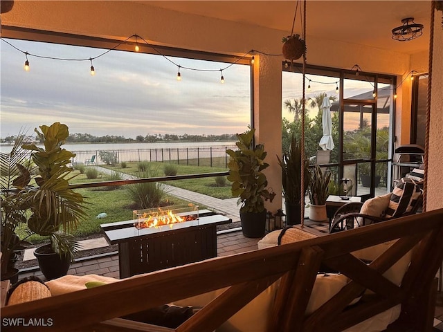 sunroom featuring a water view