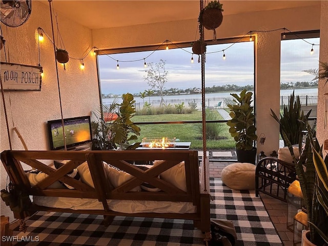 sunroom featuring a water view