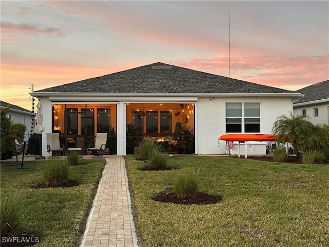 back house at dusk with a yard