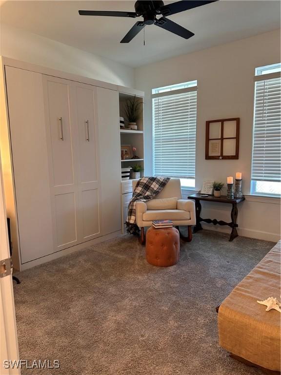 living area with ceiling fan, a healthy amount of sunlight, and carpet floors