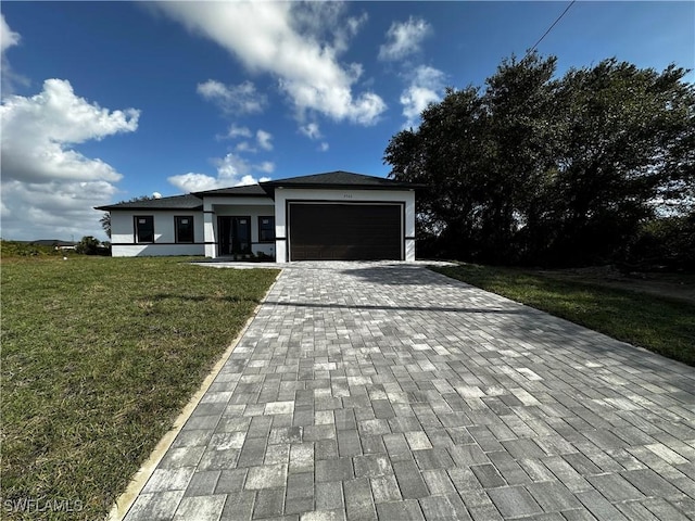 view of front of property with a front yard and a garage