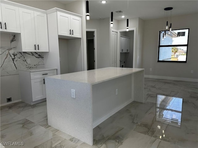 kitchen featuring white cabinets, a kitchen island, hanging light fixtures, and an inviting chandelier