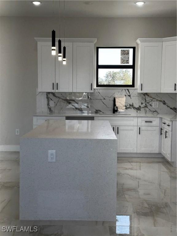 kitchen with white cabinets, hanging light fixtures, and sink