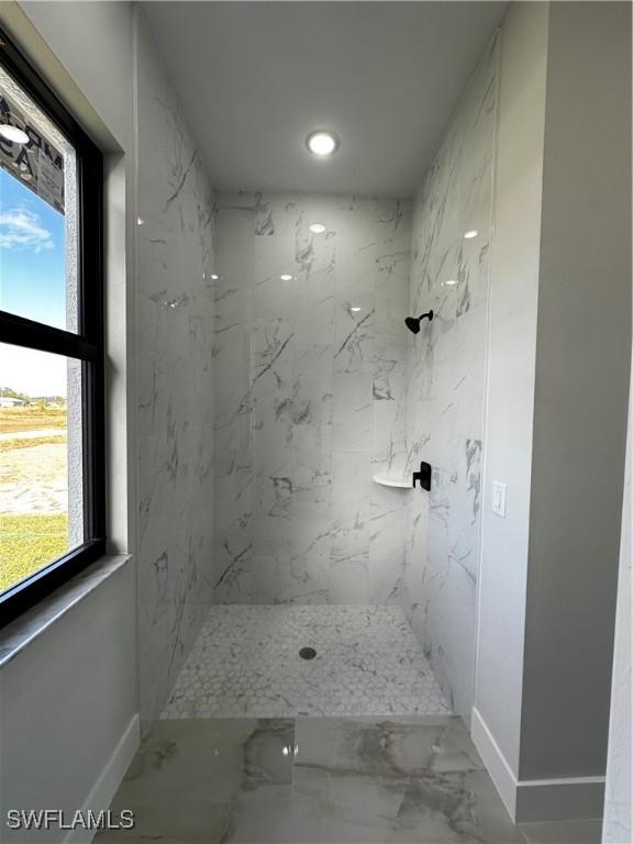 bathroom featuring plenty of natural light and tiled shower