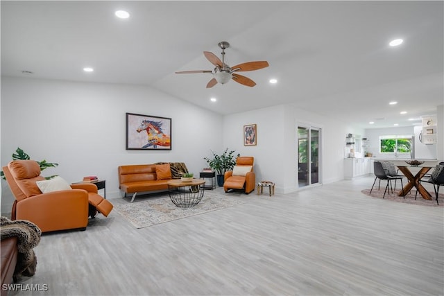 living room featuring ceiling fan, lofted ceiling, and light wood-type flooring