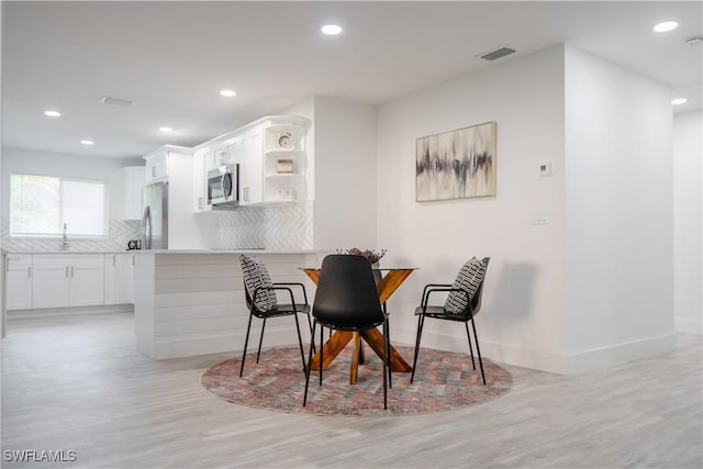 dining area featuring light hardwood / wood-style flooring and sink