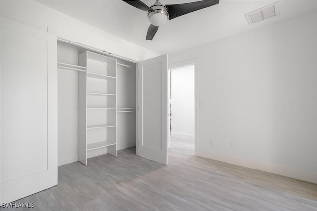 unfurnished bedroom featuring a closet, light hardwood / wood-style floors, and ceiling fan