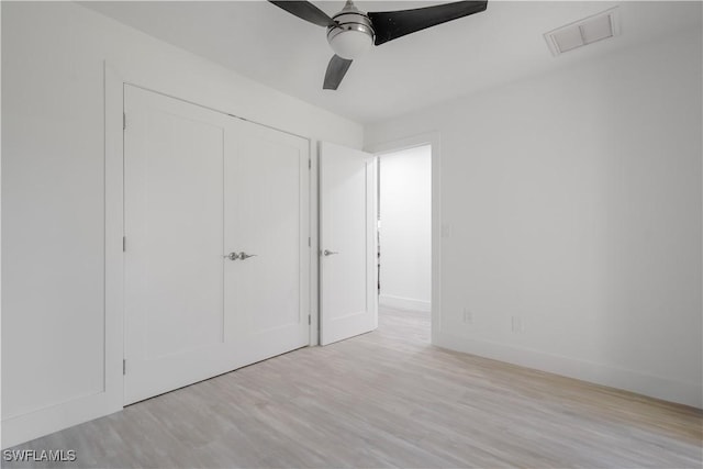 unfurnished bedroom with ceiling fan, a closet, and light hardwood / wood-style floors