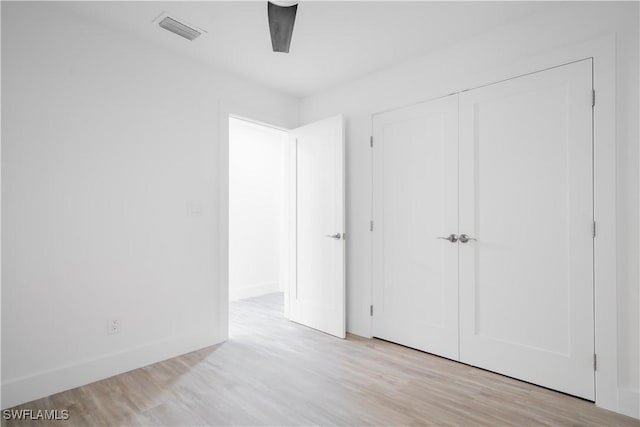 unfurnished bedroom featuring light wood-type flooring, a closet, and ceiling fan