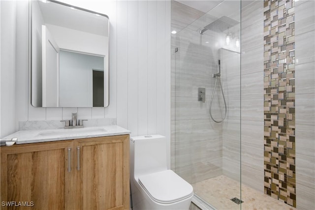 bathroom featuring vanity, toilet, and a tile shower