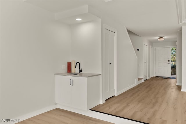 hallway featuring sink and light hardwood / wood-style floors