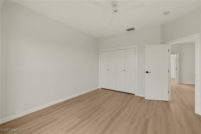 unfurnished bedroom with light hardwood / wood-style flooring, a closet, and ceiling fan