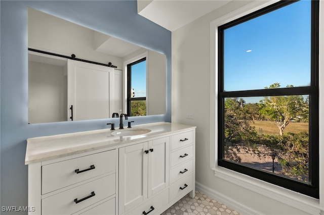 bathroom with tile patterned floors, a wealth of natural light, and vanity