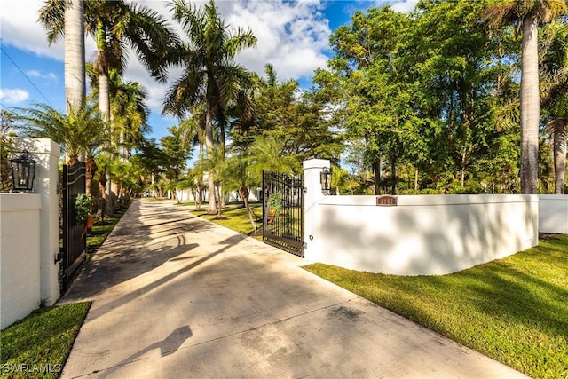 view of gate with a lawn