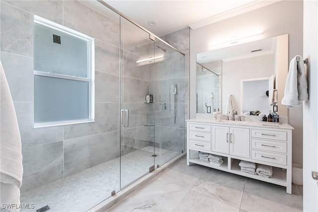 bathroom with vanity, a shower with shower door, and ornamental molding