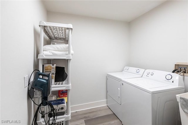 laundry area with hardwood / wood-style floors and independent washer and dryer