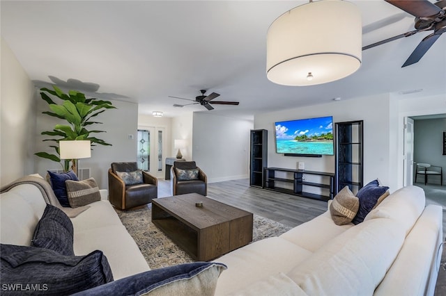 living room with wood-type flooring and ceiling fan