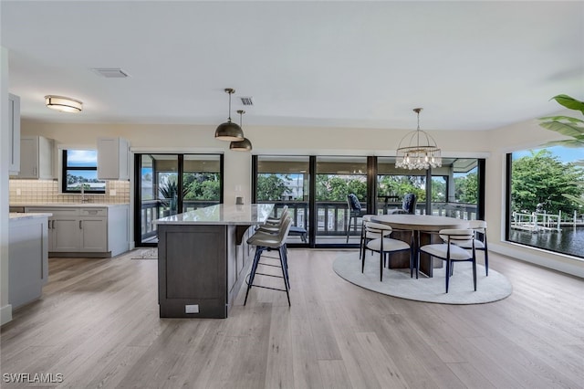 kitchen with pendant lighting, light hardwood / wood-style floors, and a kitchen island