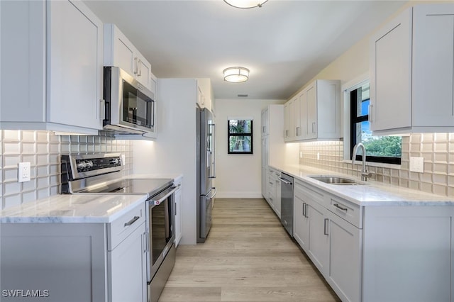 kitchen with white cabinets, appliances with stainless steel finishes, a wealth of natural light, and sink