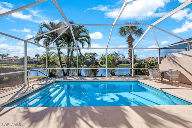 view of swimming pool with glass enclosure, a water view, and a patio