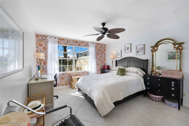 bedroom with ceiling fan, light tile patterned flooring, and a textured ceiling