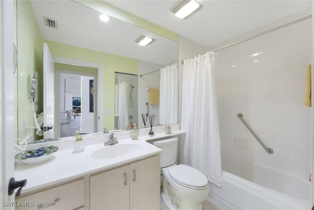 full bathroom with vanity, shower / bath combo, and toilet