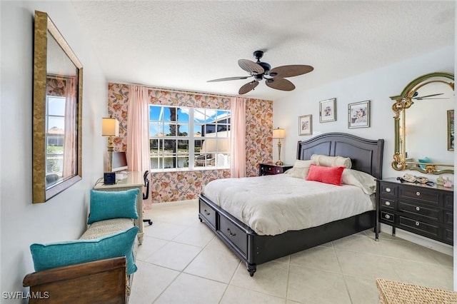 bedroom featuring a ceiling fan, light tile patterned flooring, and a textured ceiling
