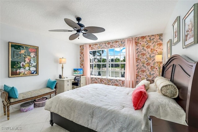bedroom with a textured ceiling, a ceiling fan, light tile patterned floors, and wallpapered walls
