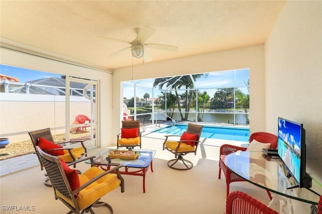 sunroom featuring ceiling fan and a pool