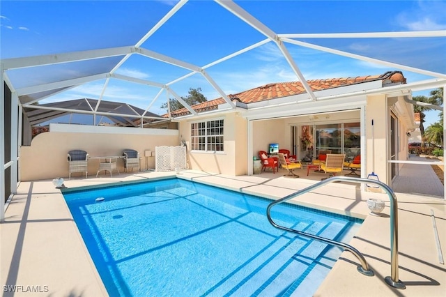 pool with a patio and glass enclosure