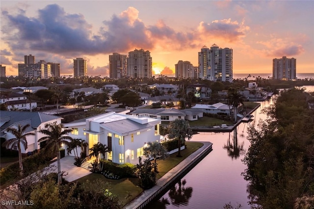 aerial view at dusk with a water view and a city view