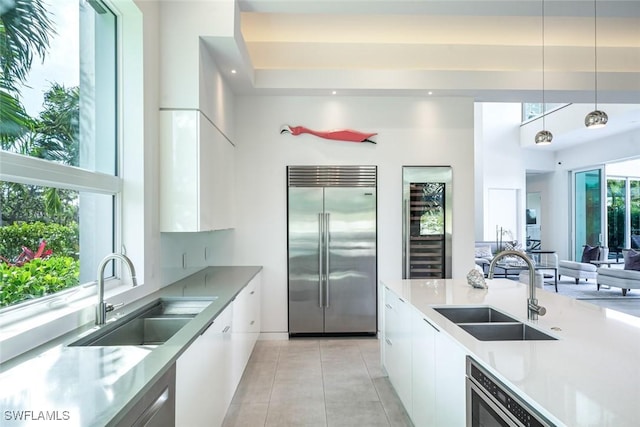 kitchen featuring a sink, built in refrigerator, and modern cabinets