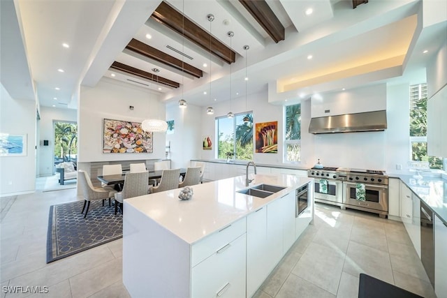 kitchen featuring a sink, white cabinets, appliances with stainless steel finishes, beamed ceiling, and modern cabinets