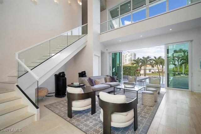 living area with stairway and a high ceiling