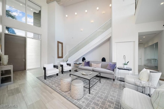 living area featuring stairway and a towering ceiling