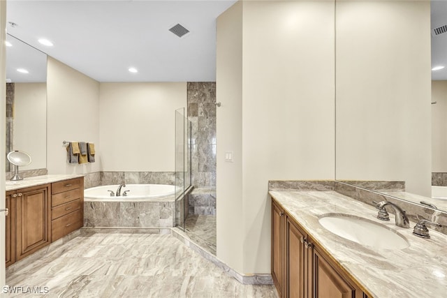 bathroom featuring vanity and independent shower and bath