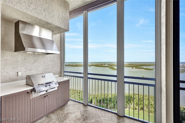 sunroom featuring a water view