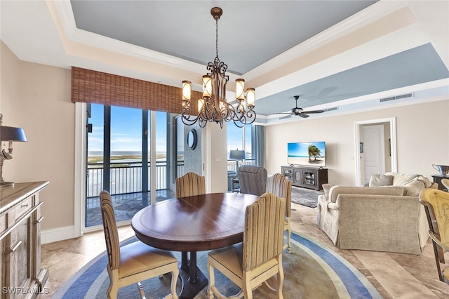 dining space with ceiling fan with notable chandelier, crown molding, and a tray ceiling