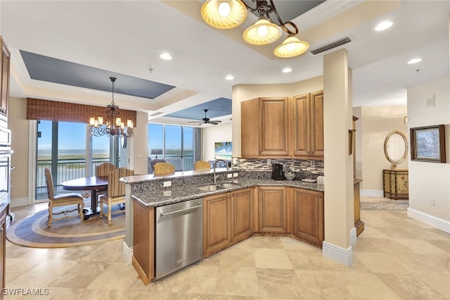 kitchen with kitchen peninsula, sink, stainless steel appliances, and ceiling fan with notable chandelier