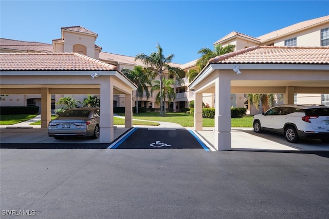 view of parking with a carport and a yard