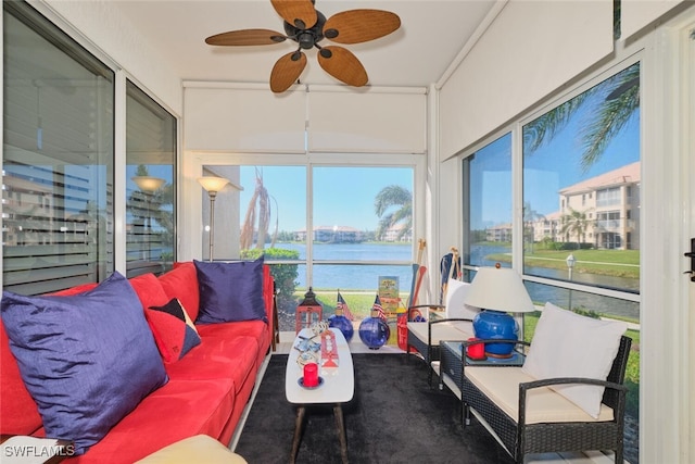 sunroom / solarium featuring ceiling fan and a water view