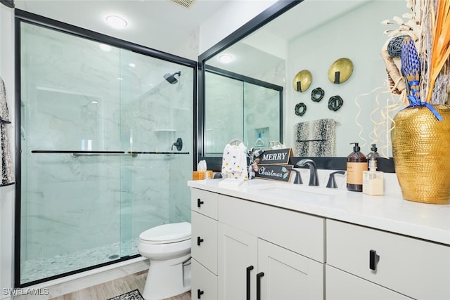 bathroom with vanity, wood-type flooring, an enclosed shower, and toilet