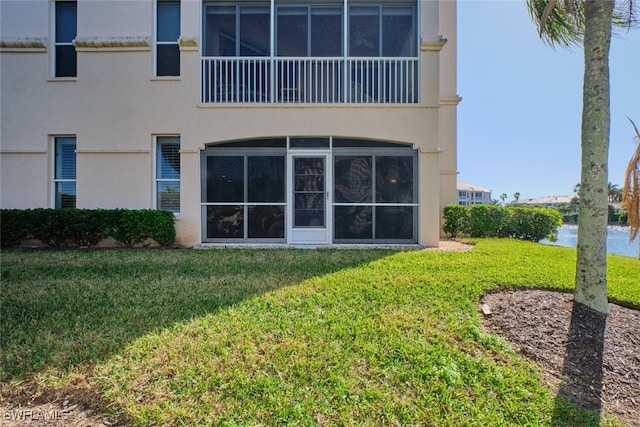 rear view of property with a lawn and a water view