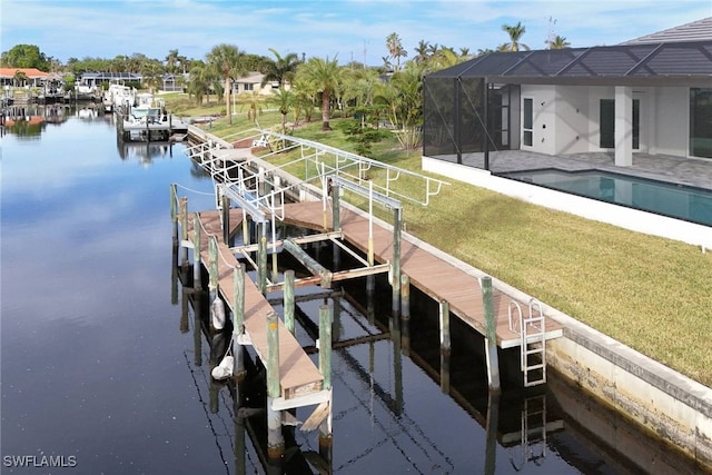 view of dock featuring a lawn, glass enclosure, a water view, and a patio