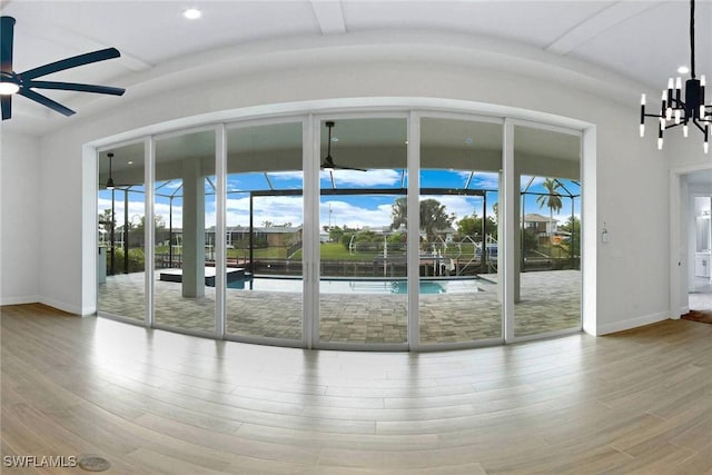 entryway with ceiling fan with notable chandelier, beam ceiling, and light wood-type flooring