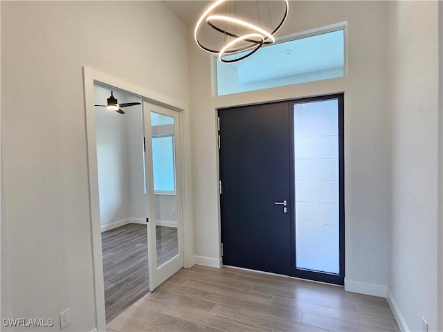 foyer with plenty of natural light, light hardwood / wood-style floors, ceiling fan, and french doors