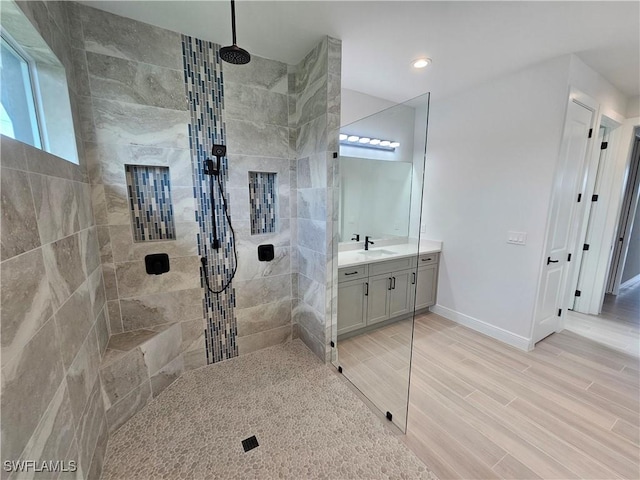 bathroom featuring tiled shower and vanity