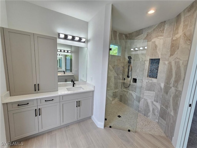 bathroom with vanity and tiled shower