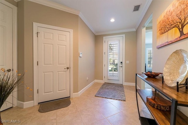 entryway with ornamental molding and light tile patterned floors