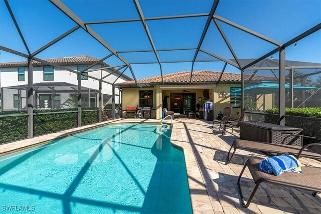 view of pool featuring glass enclosure and a patio area